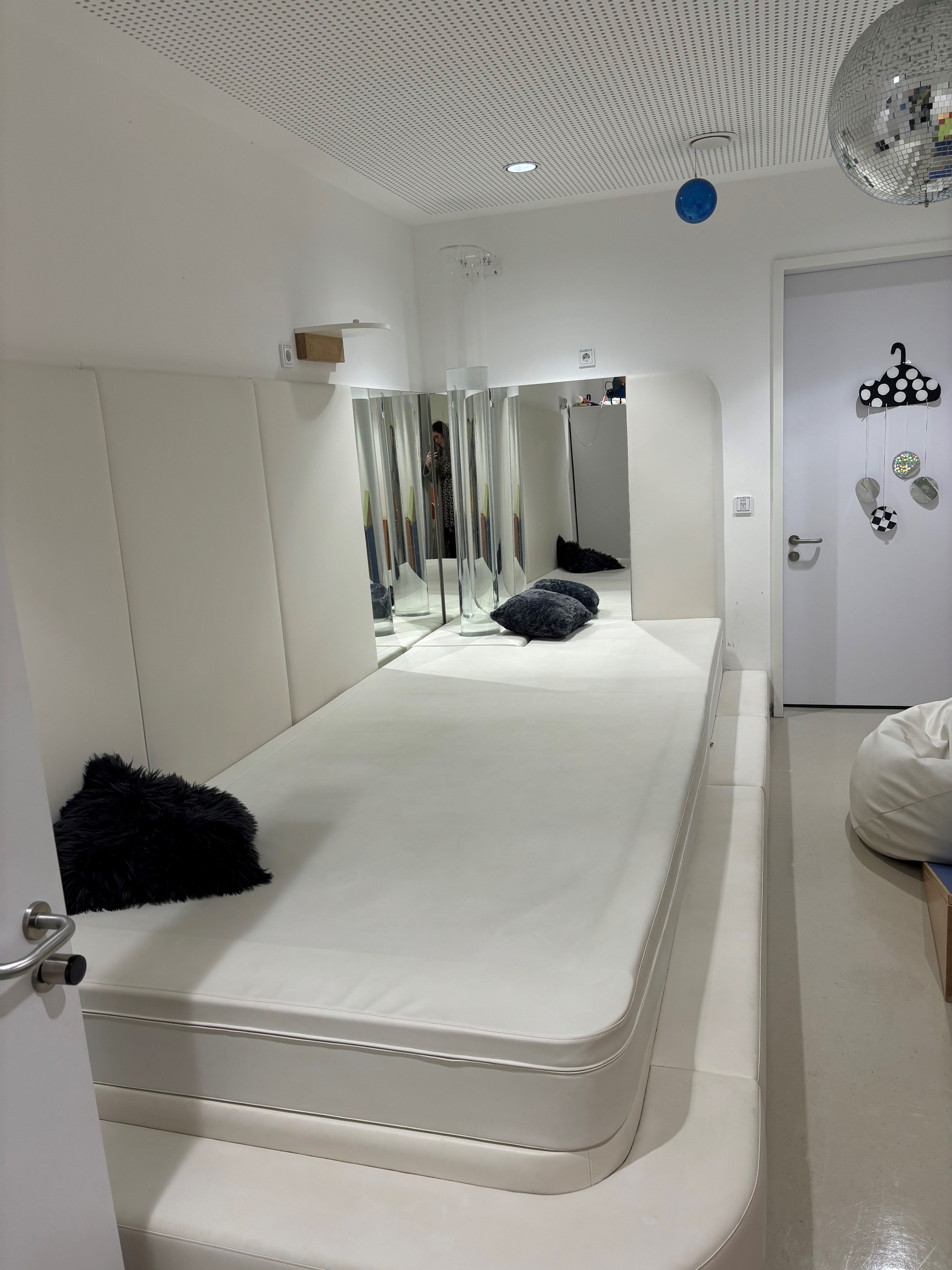 Ruheraum mit Matratze auf dem Boden und Spiegel an der Wand